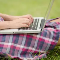 Girl working on laptop outside compressed